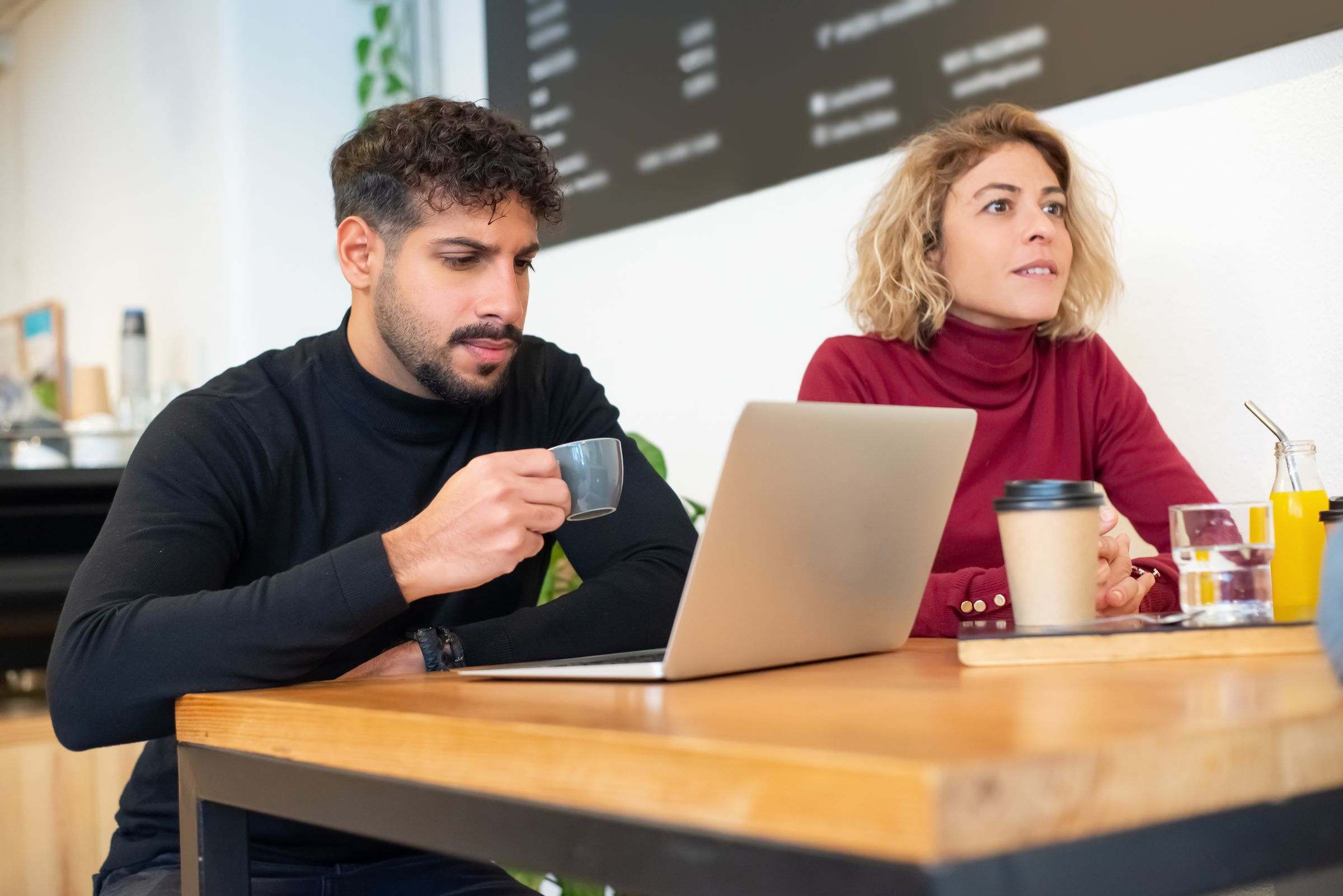 Foto de referencia: un hombre y una mujer conversan en una cafetería